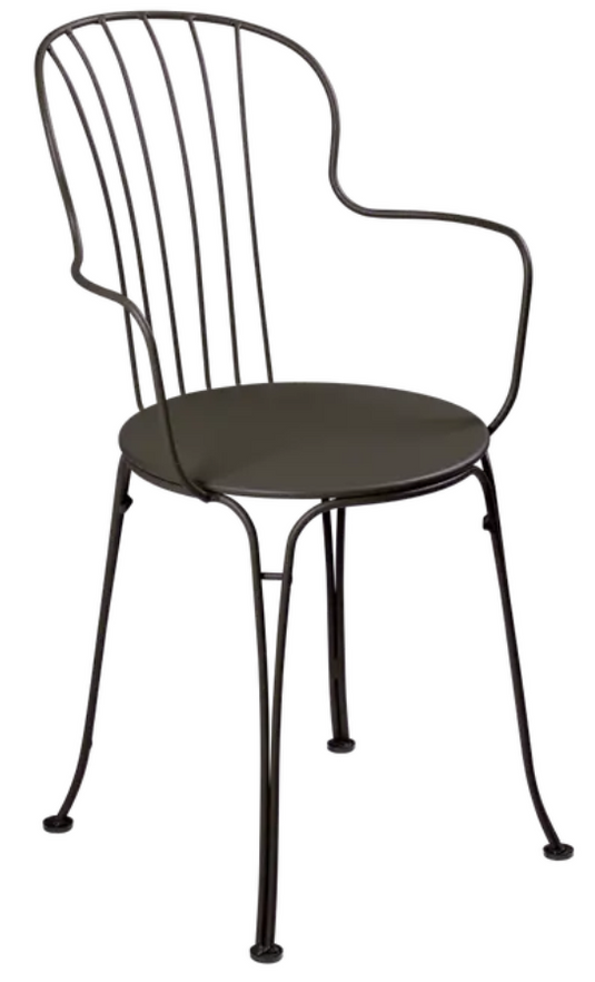 Fermob OPÉRA+ outdoor metal armchair with a sleek, modern design, shown in a vibrant yellow color on a patio.