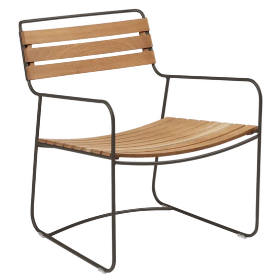 Fermob Surprising Teak Low Armchair made of metal, outdoor furniture with a modern design, shown in a stylish outdoor setting.