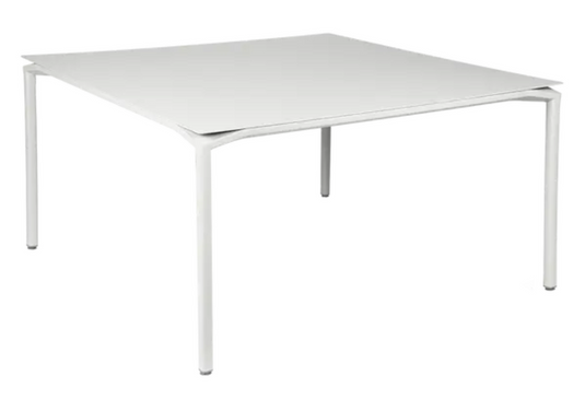 White Fermob CALVI square dining table, 140x140 cm, designed for eight seats, with a sleek metal surface.