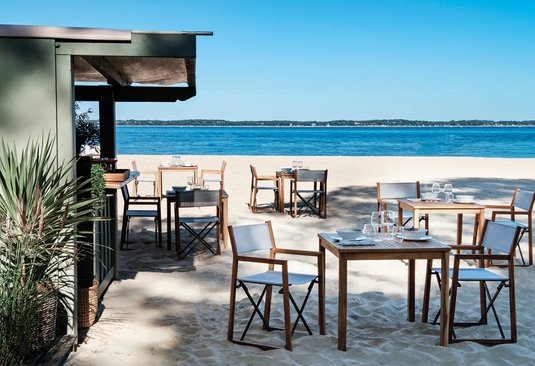 Fermob ZÉNITH teak foldable director’s chair with armrests, beach-style design, lightweight and portable for outdoor use.