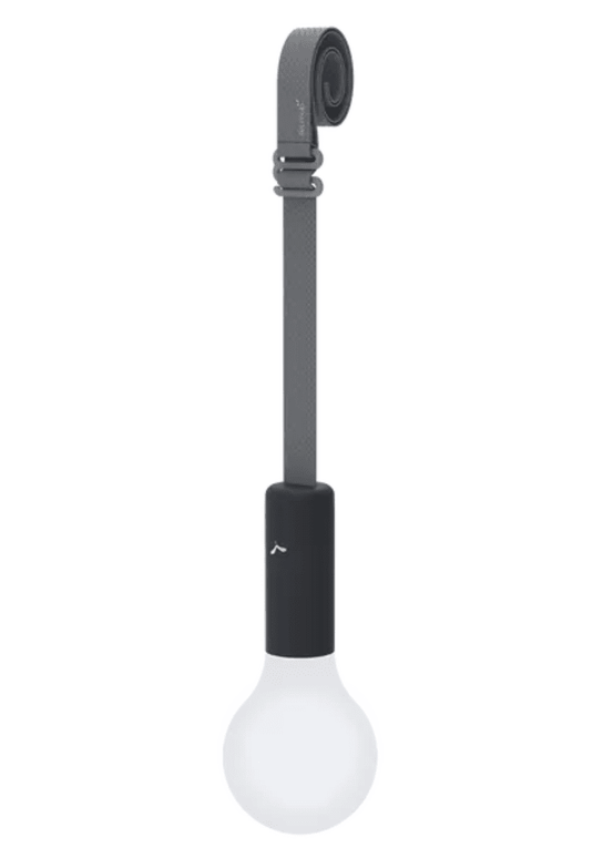 Fermob APLÔ suspended lamp with an anthracite finish and adjustable suspension strap, hanging as a stylish, rechargeable light.