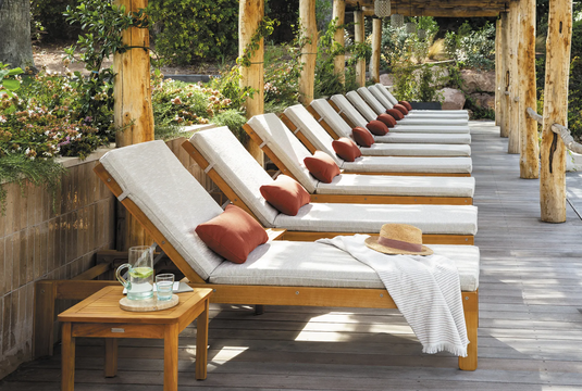 Fermob IBIZA teak outdoor sunlounger with a sleek wooden frame, designed for relaxing on the beach or patio.