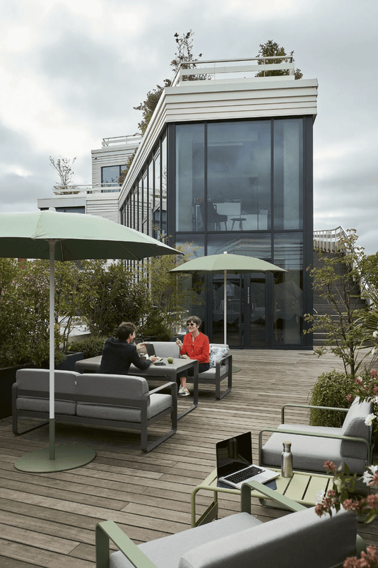 Fermob Bellevie 2-Seater outdoor sofa with light grey cushions and woven metal frame, perfect for patio relaxation.