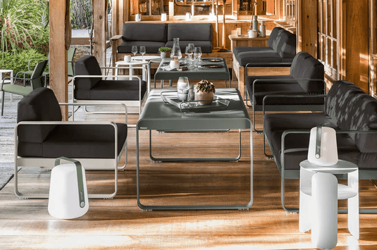 Fermob Bellevie armchair with metal frame and cushioned seat in a modern design, set on a stylish outdoor patio.