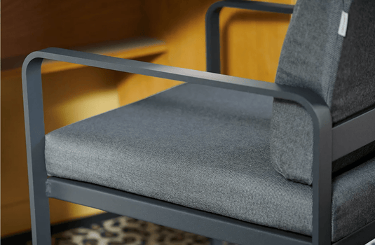 Fermob Bellevie outdoor dining armchair with a nutmeg gray finish, featuring a sturdy frame and comfortable armrests.