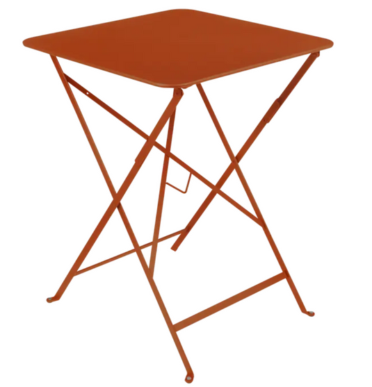 Candied orange Fermob metal foldable bistro table, 57x57 inches, outdoor cafe style with a sleek, durable design.