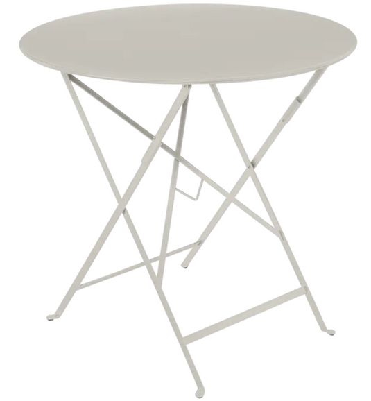 Clay grey Fermob round outdoor bistro table, Ø77cm, folding metal design, perfect for four-seat cafe or patio setup.