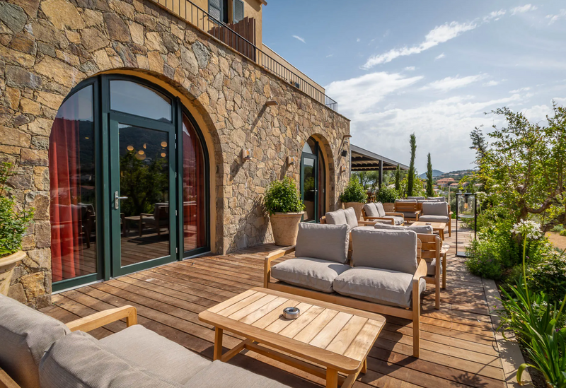 Load image into Gallery viewer, Fermob Lodge outdoor teak armchair with low armrests, designed for hotel terrace or outdoor seating, showcasing sleek teak finish.
