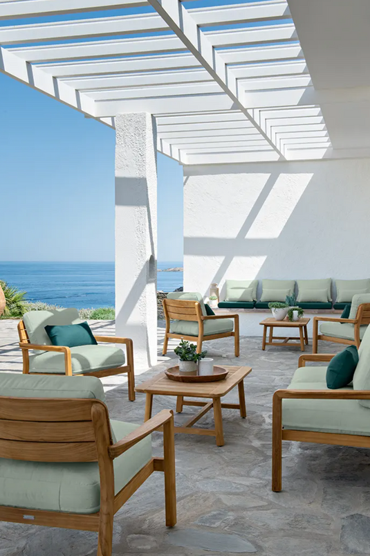 Fermob Lodge outdoor teak armchair with low arms, designed for hotel terrace seating, featuring a stylish and durable outdoor design.