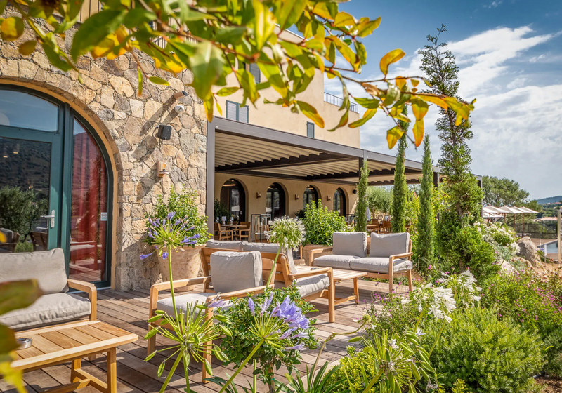 Load image into Gallery viewer, Lodge Fermob outdoor teak armchair with low armrests, suitable for hotel terrace seating, featuring a modern design.
