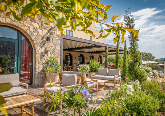 Lodge Fermob outdoor teak armchair with low armrests, suitable for hotel terrace seating, featuring a modern design.