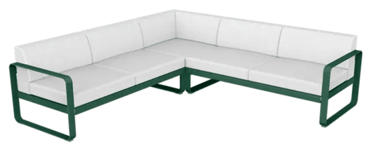 Fermob Bellevie modular outdoor sofa set with cedar, green, and off-white cushions in a stylish garden setting