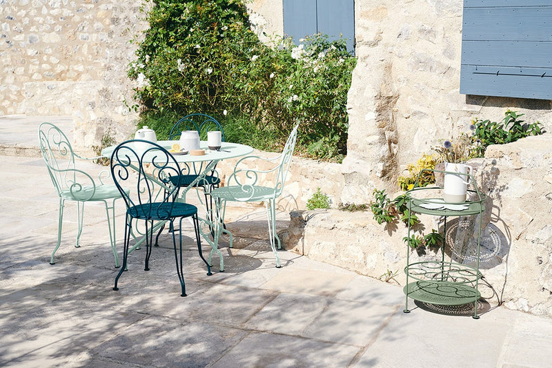 Load image into Gallery viewer, Fermob Montmartre chairs and round table in Ice Mint on a sunny stone patio
