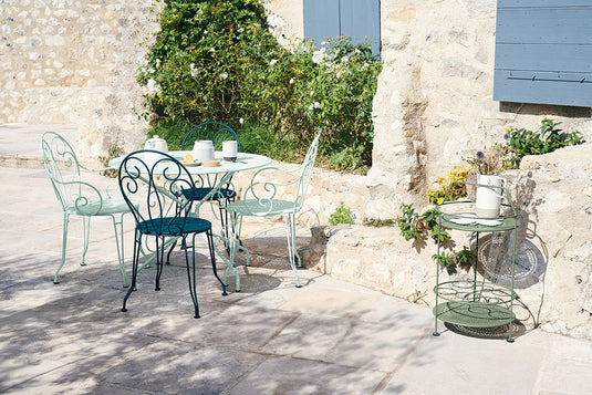 Fermob Montmartre chairs and round table in Ice Mint on a sunny stone patio