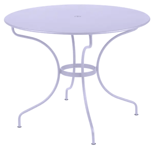 Fermob OPÉRA+ outdoor metal table with a 96 cm diameter, designed for five seating, in a stylish outdoor patio setting.