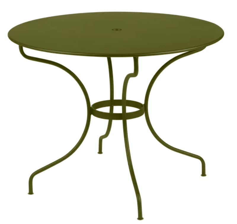 Load image into Gallery viewer, Fermob OPÉRA+ outdoor metal table with a 96 cm diameter, stylish five-seater design in a pesto finish on a patio.

