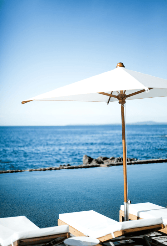 Fermob IBIZA teak sunlounger with a slatted outdoor bed and adjustable backrest on a beach setting in Ireland.