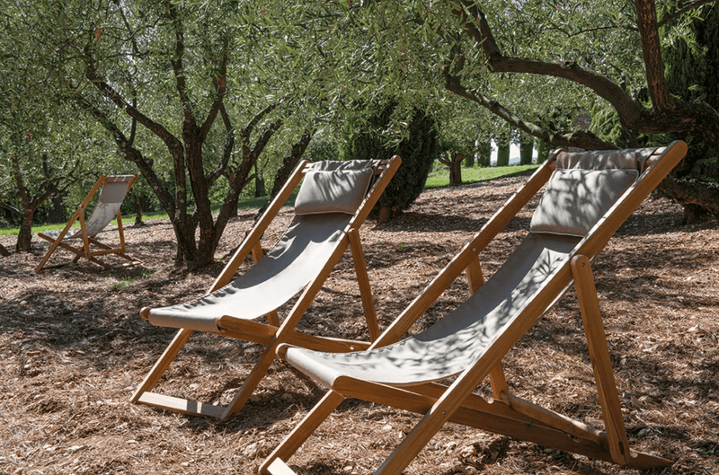 Load image into Gallery viewer, Fermob IBIZA teak deckchair with a natural wood finish, featuring a slatted design and sturdy armrests for outdoor lounging.
