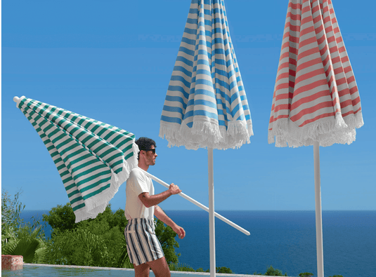Fermob KOTO Teak Parasol in Ireland sizes Ø200cm and Ø250cm, featuring a stylish fringe detail on a natural teak finish.
