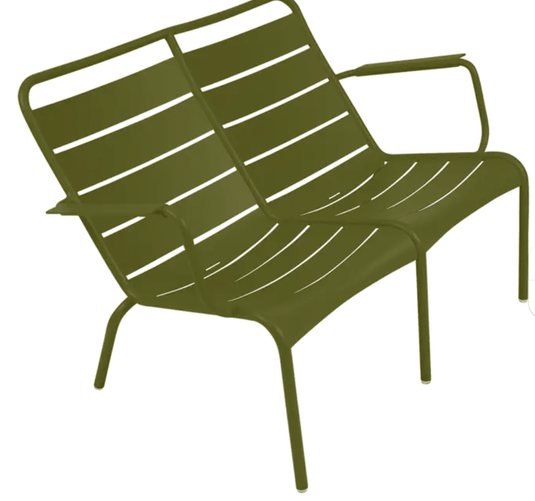 Luxembourg Duo low armchair by Fermob in Pesto Green, featuring a modern, curved design with a wooden frame and fabric cushion.