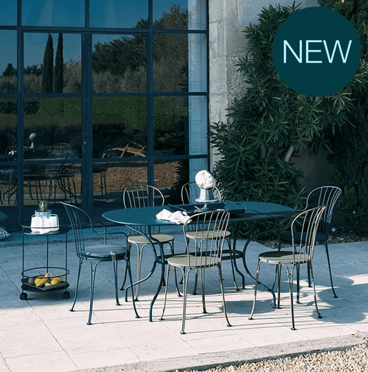 Fermob OPÉRA+ outdoor metal chair with a sleek design, featuring a curved backrest and armrests, ideal for patio seating.