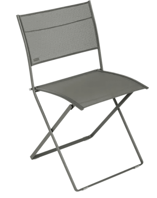 Fermob Plein Air folding chair in outdoor setting, featuring a lightweight design and colorful fabric seat for comfortable relaxation.