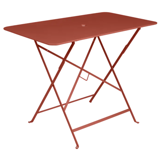 Red ochre Fermob metal foldable bistro table with 97x57 cm size, suitable for outdoor cafe or patio use.