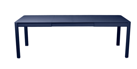 Deep blue Fermob Ribambelle extendable metal table set for 10, perfect for outdoor hospitality with aluminum design.