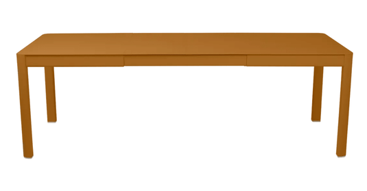 Fermob Ribambelle extendable metal table, 10-seater large outdoor aluminum dining table in gingerbread color.