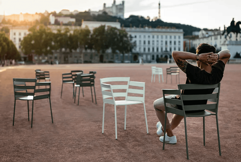 Load image into Gallery viewer, Fermob RYTHMIC outdoor armchair with a modern design, featuring a sleek metal frame and colorful woven seat for outdoor relaxation.
