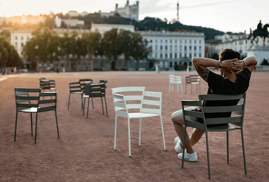 Fermob RYTHMIC outdoor armchair with a modern design, featuring a sleek metal frame and colorful woven seat for outdoor relaxation.