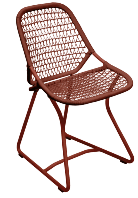 Red ochre Fermob Sixties outdoor chair with a stylish modern design, ideal for restaurant and hospitality outdoor seating.