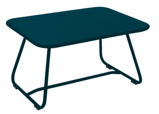 Fermob Sixties low outdoor table in Acapulco Blue, measuring 76x55.5cm, with a sleek, modern design for patio or garden use.