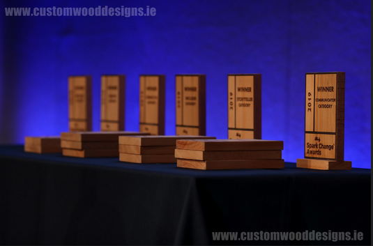 Custom wood sports trophies with engraved logos and text, made by Custom Wood Designs in Ireland, showcasing eco-friendly wooden awards.