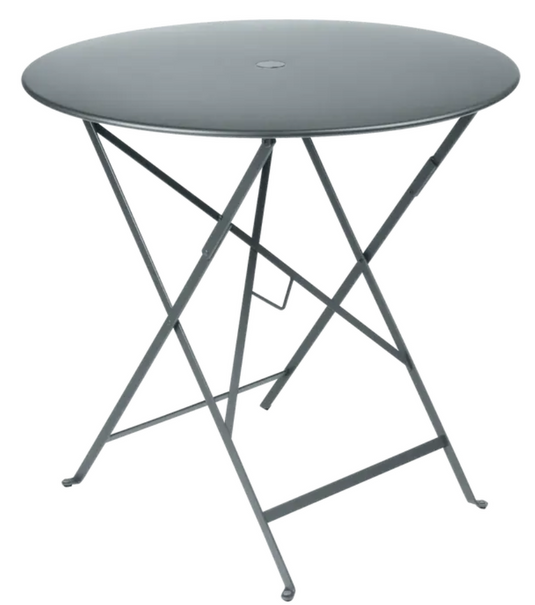 Fermob Storm Grey 77cm round outdoor bistro table with folding metal design, ideal for small outdoor dining or cafe spaces.