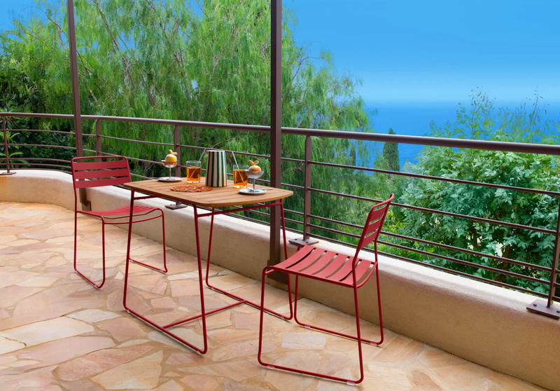 Load image into Gallery viewer, Fermob Surprising outdoor chair with curved metal frame and colorful woven seat, ideal for patio or garden seating.
