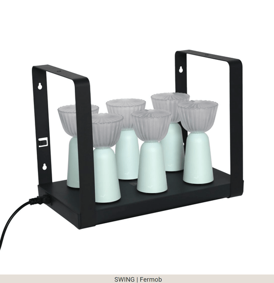 Set of six Fermob Swing rechargeable outdoor lamps with charging tray, stylish and portable lighting for outdoor spaces.