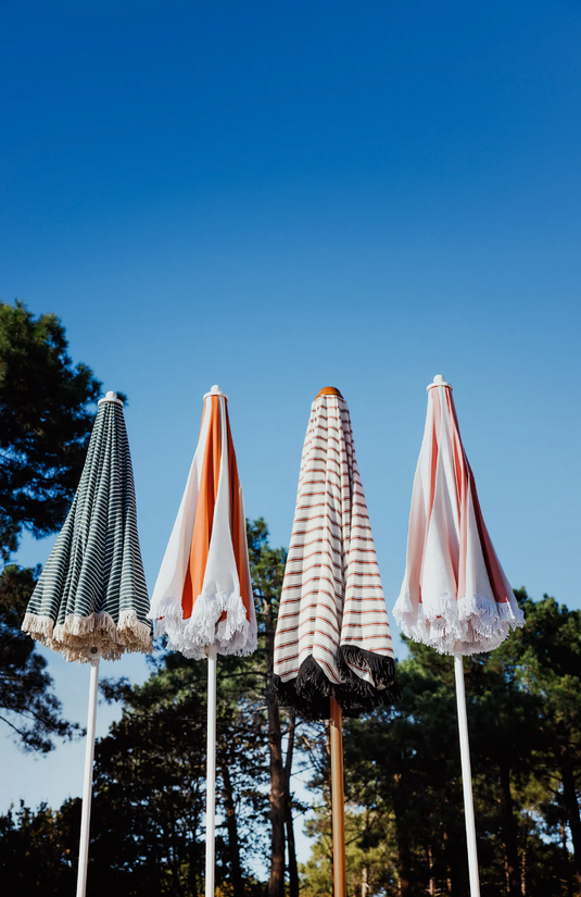 Aluminium Fermob outdoor parasol with a 250cm diameter on a terrace, providing shade for outdoor dining or relaxation.