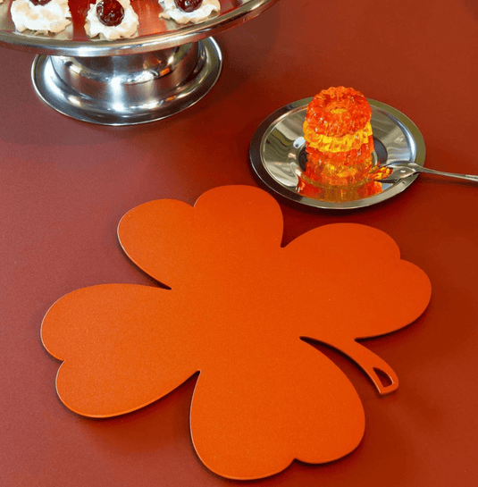 Fermob TRÈFLE metal non-slip pad trivet, 27x27 cm, with a decorative orange candied design for protecting surfaces.