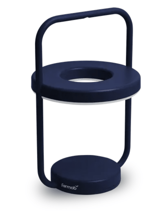 Fermob ULLI Monochrome outdoor lamp in deep blue, 30 cm height, illuminated and charging for outdoor lighting ambiance.